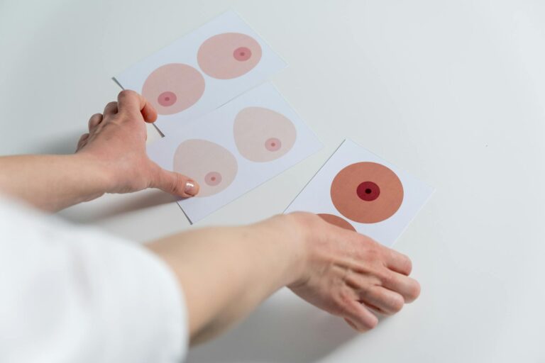 Image of hands arranging breast anatomy illustrations for awareness and education.